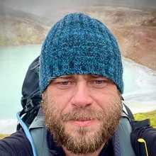 Maciej Budzich w czapce nad geotermalnym jeziorkiem na Islandii